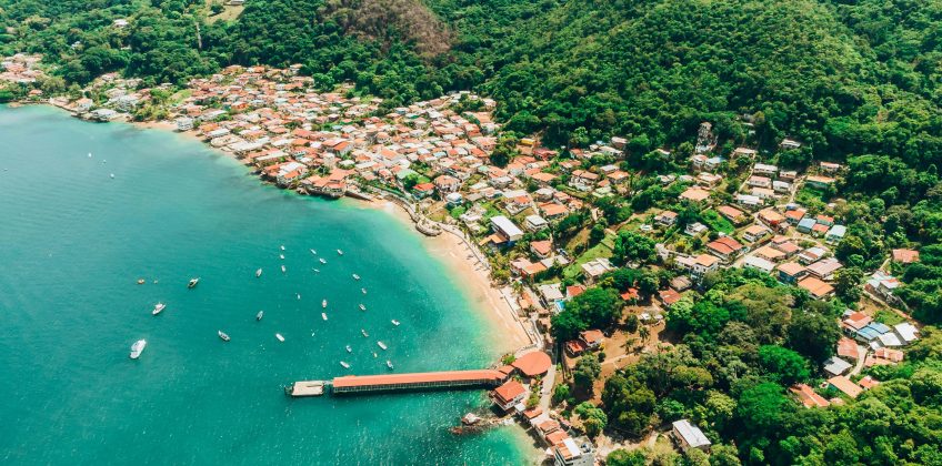 A breathtaking aerial shot of Taboga Island's coastline, showcasing turquoise waters and lush hills.