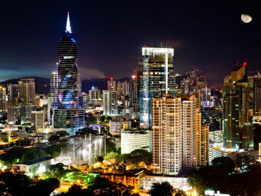 Illuminated skyscrapers under a moonlit sky in Panama City's vibrant urban landscape.